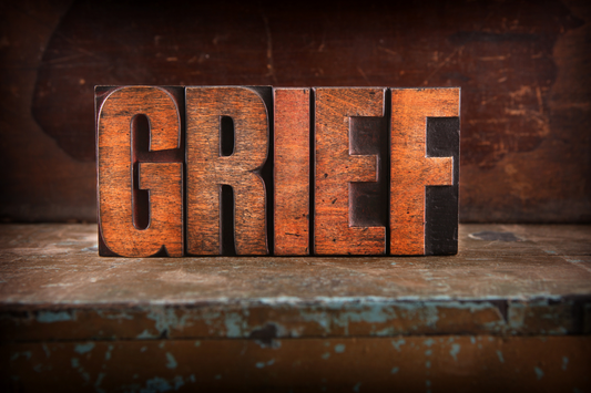 The word Grief is in burnt orange and dirty looking. Relief Support-Navigating Grief-Embracing the Unavoidable Visitor